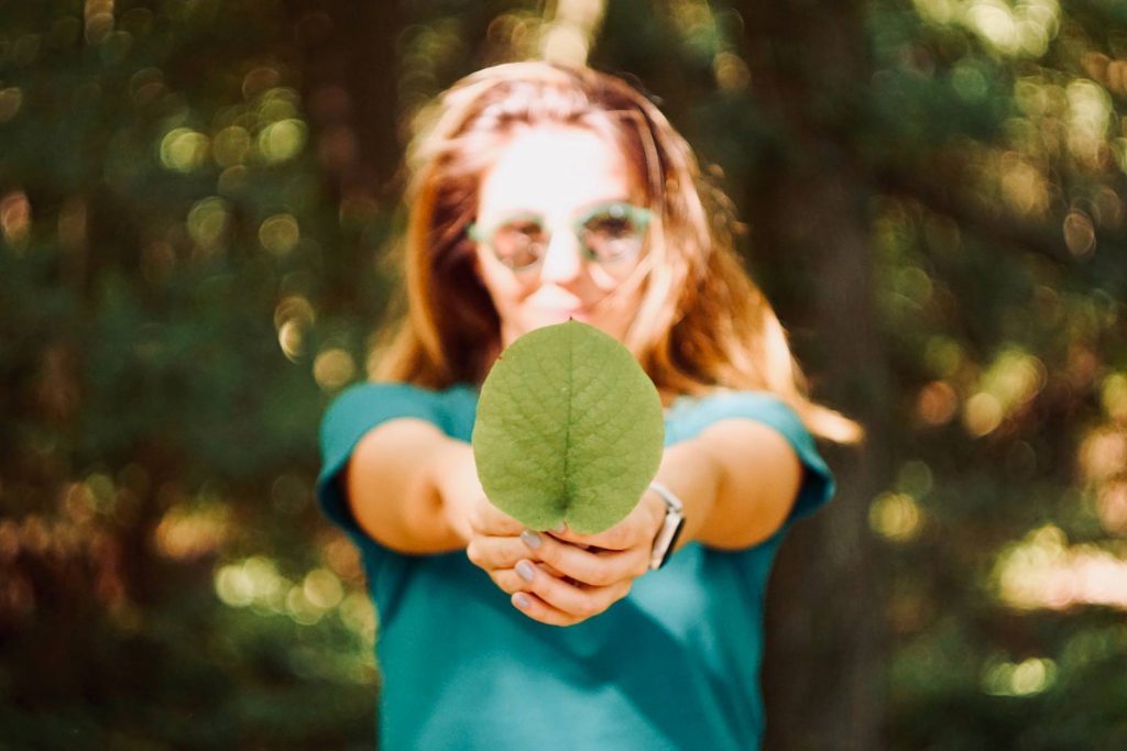 young girl with big green leaf