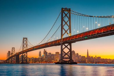 Night scene of San Francisco's Oakland Bay Bridge with the San Francisco skyline in the background